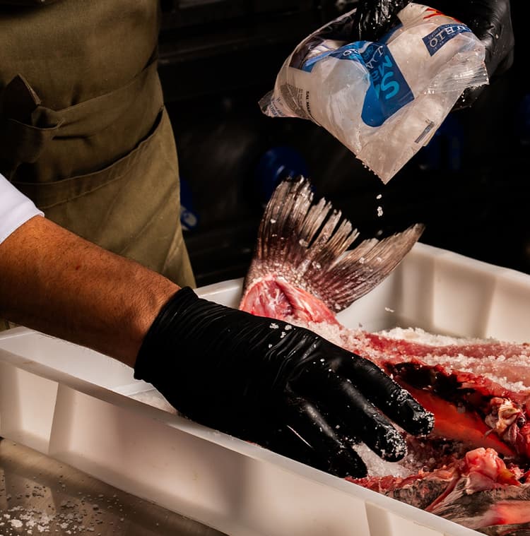 Imagen de una persona salando pescado