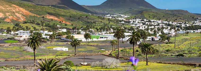 Village of Haría, town of flowers and palm trees with the majestic volcano of La Corona in the background